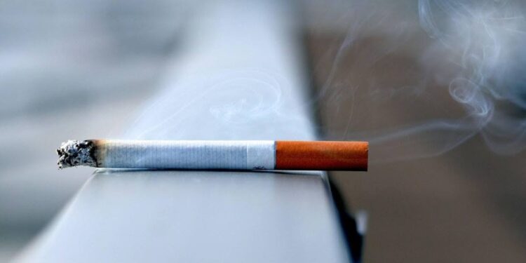 A burning cigarette placed on a handrail